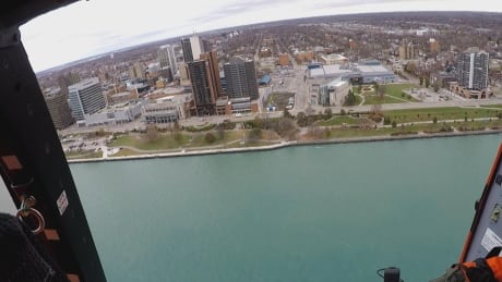 U.S. Coast Guard Air Station Detroit flies along the Detroit River, next to downtown Windsor. U.S. Coast Guard Air Station Detroit 4