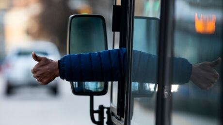 A bus driver gives a thumbs up while driving in Vancouver, British Columbia on Wednesday, November 27, 2019. TRANSIT RESOLUTION