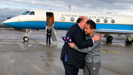 This photo provided by U.S. Embassy Switzerland, Edward McMullen greets Xiyue Wang in Zurich, Switzerland on Saturday, Dec. 7, 2019. In a trade conducted in Zurich, Iranian officials handed over Chinese-American graduate student Xiyue Wang, detained in Tehran since 2016, for scientist Massoud Soleimani, who had faced a federal trial in Georgia. (U.S. Embassy Switzerland via AP) Iran US