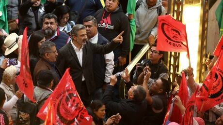 Miguel Fernandez, director of the Palace of Fine Arts Museum, talks with farmers who block the entrance to the Fine Arts Palace protesting against a painting showing Emiliano Zapata straddling on a horse nude, wearing high heels and a pink, broad-brimmed, in Mexico City, Tuesday, Dec. 10, 2019. The work, by painter Fabian Chairez, is part of an exhibit remembering the one hundred anniversary of the revolutionary hero death. Mexico Zapata