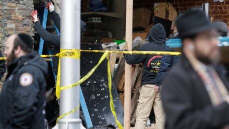 Bullet holes are seen on a piece of metal as people worked on Wednesday to secure the scene of a shooting at the kosher supermarket in Jersey City, N.J.
Shooting Jersey City