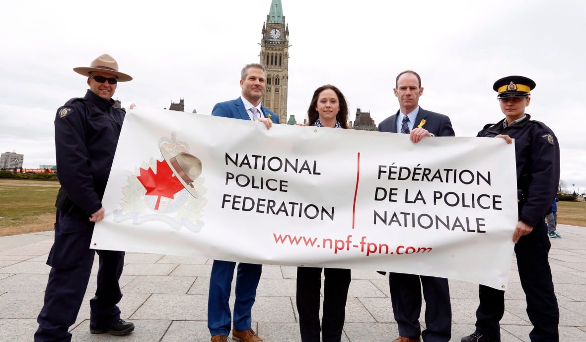 Mitglieder der Royal Canadian Mounted Police (RCMP) halten am Mittwoch, den 12. April 2017, ein Banner auf dem Parliament Hill. Von links nach rechts: Constable Eric Decoste, Dennis Miller, Lorette Jones, Brian Sauve und Maria Pikus. Die Mounties protestieren gegen Löhne, Personalstand und Arbeitsbedingungen, indem sie die gelben Streifen an den Seiten ihrer Hosen entfernen.