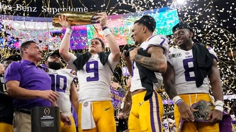 LSU quarterback Joe Burrow holds the championship trophy after his team's 42-25 win against Clemson in the NCAA football title game on Monday. burrow-o-011320