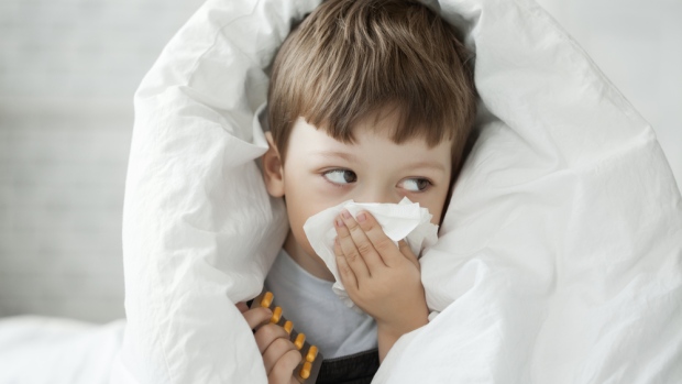 What is walking pneumonia, and why does it seem to be on the rise?; A sick child with a cold wipes his nose with a tissue\.