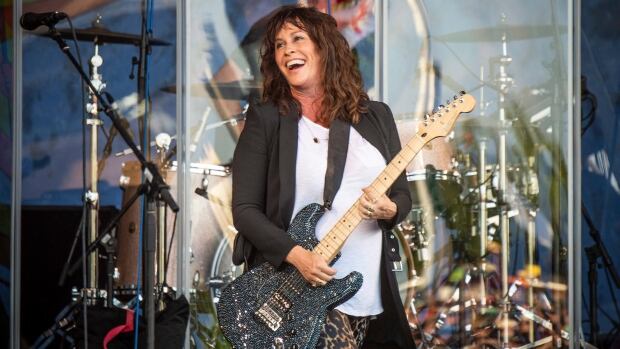 Alanis Morissette performs at the New Orleans Jazz and Heritage Festival on Thursday, April 25, 2019, in New Orleans. Alanis Morissette holds a sparkly guitar as she performs on stage at the New Orleans Jazz and Heritage Festival.