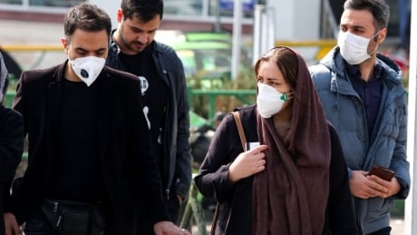 Iranians, some wearing protective masks, wait to cross a street in the capital Tehran on February 22, 2020. - Iran today reported one more death among 10 new cases of coronavirus, bringing the total number of deaths in the Islamic republic to five and infections to 28. (Photo by ATTA KENARE / AFP) (Photo by ATTA KENARE/AFP via Getty Images) 1202388505