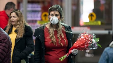 A woman waits for a passenger to arrive through international arrivals at Vancouver’s international airport (YVR) in Richmond, British Columbia on Friday, March 13, 2020. COVID-19 TRAVEL ADVISORY