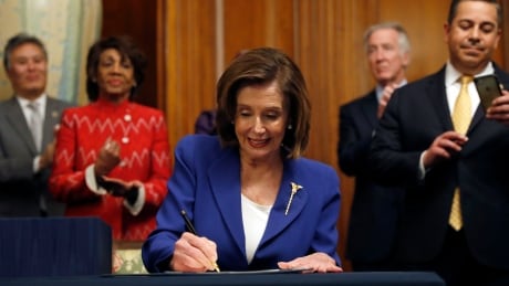 House Speaker Nancy Pelosi of Calif. accompanied by other legislators, signs the Coronavirus Aid, Relief, and Economic Security (CARES) Act after it passed in the House on Capitol Hill on Friday.
Virus Outbreak Congress