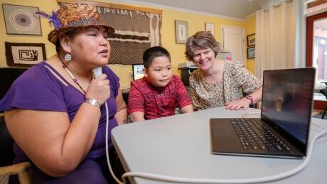 Sharon Seymour demonstrating the ultrasound tools that show the inside of her mouth when speaking with her son and professor Sonya Bird. Hul'q'umi'num' language