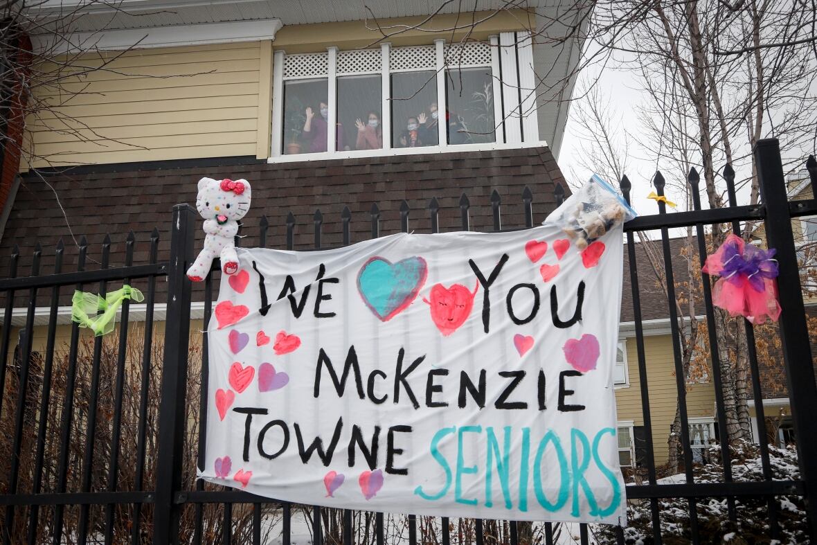 A homemade "we love you Mckenzie Towne seniors" sign hangs on a fence. 