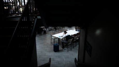 A man sits by himself at the Vancouver International Airport (YVR) in Richmond, B.C., on March 17, 2020. COVID-19 TRAVEL VANCOUVER AIRPORT