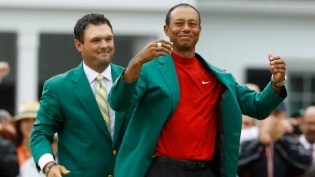 Tiger Woods is seen above receiving the green jacket after winning the Masters last April. The major golf tournament has been postponed with organizers aiming to hold the event in November. Masters Postponed Golf
