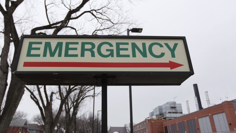 A sign reads "emergency" outside a hospital building.
