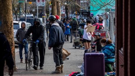 Crowds of people are pictured in the downtown Eastside in Vancouver, British Columbia on Wednesday, March 25, 2020. COVID-19 DTES CHEQUE DAY