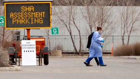 A nurse in personal protective equipment walks with a patient into a Saskatchewan Health Authority assessment centre, set up to test people who are showing symptoms of COVID-19. Saskatchewan Health Authority COVID-19 Assessment site nurse PPE patient Coronavirus