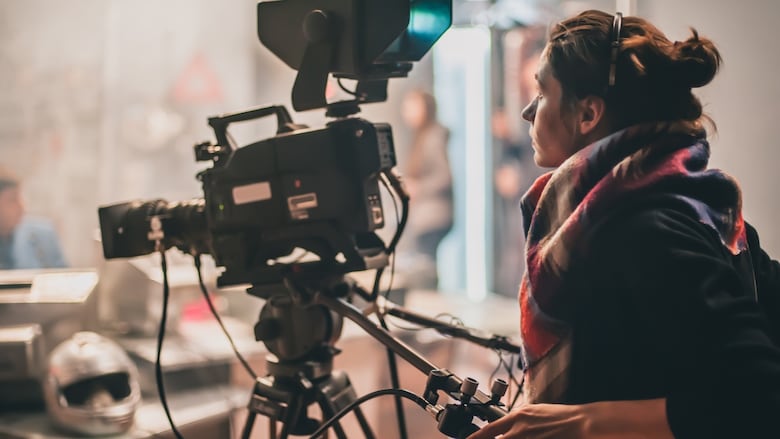 A person operating a large camera.