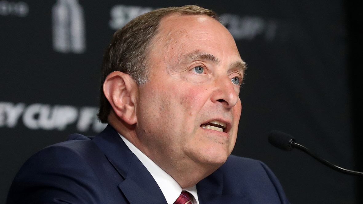 NHL Commissioner Gary Bettman (R) listens to a question during a