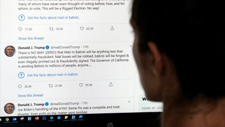 This illustration photo shows an editor in Los Angeles looking at the official Twitter account of US President Donald Trump on May 26, 2020, with two tweets by the president under which Twitter posted a link reading "Get the facts about mail-in ballots". - Twitter labelled two of Donald Trump's tweets misleading on May 26, a first for the social media network which has long resisted calls to censure the US President over his frequent abuse, insults and false claims. Trump's tweets contended without evidence that mail-in voting would lead to fraud and a "Rigged Election." 1215361926