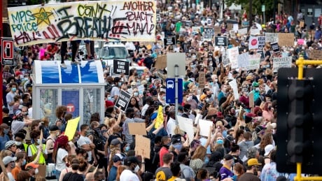 Protesters gather to call for justice for George Floyd on Tuesday in Minneapolis. Four Minneapolis officers involved in the arrest of Floyd, a black man who died in police custody, were fired Tuesday, hours after a bystander's video showed an officer kneeling on the handcuffed man’s neck. APTOPIX Minneapolis Police Death