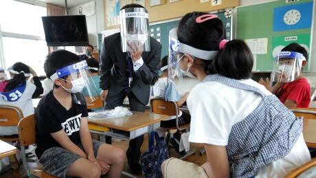 Elementary school students wearing face masks and face shields amid concerns over the spread of the COVID-19 coronavirus attend a class in Koka City, Shiga prefecture on June 1, 2020, one week after the Japanese government lifted the state of emergency nationwide. 1216629298