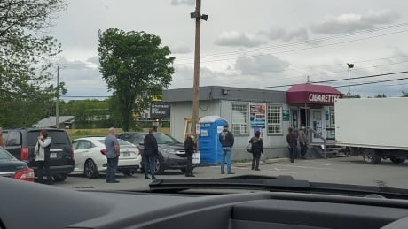 Long lines of customers waited outside of tobacco shops along Highway 132 in Kahnawake, Que. as stores reopened on June 1. Kahnawake stores