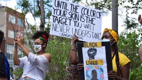 Three women stand at an anti-Black racism demonstration in downtown Guelph on Saturday. Thousands gathered in Guelph, Ont., on Saturday, June 6, 2020 for a Black Lives Matter solidarity march.