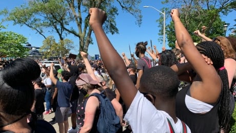 Fists in the air during a moment of silence at the Black Lives Matter rally on the Windsor waterfront Sunday. Fists in the air