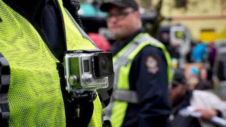 A member of the Vancouver Police Department wears a chest-mounted GoPro camera as he oversees the takedown of a tent city in downtown Vancouver on Oct. 16, 2014. vancouver police department body camera