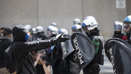 A protester comes face-to-face with Montreal police at an anti-racism demonstration downtown June 7, 2020. Montreal Black Lives Matter protest