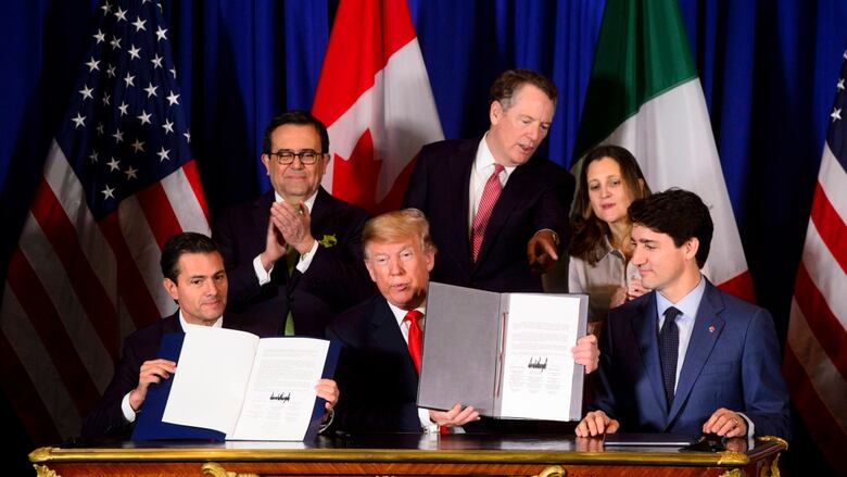 Trudeau, Pena Nieto and Trump hold up newly signed copies of the CUSMA pact in 2018