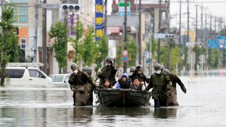 Japan Self Defence Force members rescue residents on a boat on a flooded road hit by heavy rain in Omuta, Fukuoka prefecture, southern Japan on Tuesday. Rescue operations continued and rain threatened wider areas of the main island of Kyushu. Japan Floods
