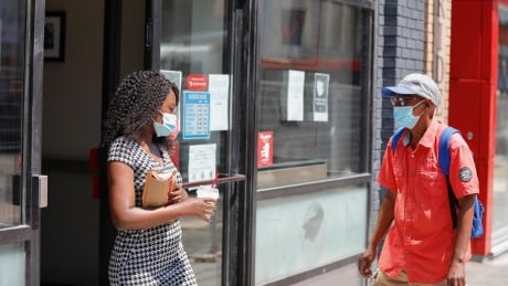 See masked people going in and out of a Tim Hortons location. Photo taken on July 9 2020. Summer day, Ottawa