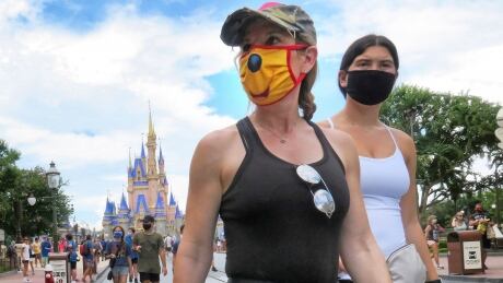 Guests wear masks as required to attend the official reopening day of the Magic Kingdom at Walt Disney World in Lake Buena Vista, Fla., Saturday, July 11, 2020. Disney reopened two Florida parks, the Magic Kingdom and Animal Kingdom, Saturday with limited capacity and safety protocols in place in response to the coronavirus pandemic. Virus Outbreak Disney