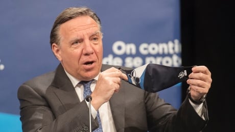 Quebec Premier Francois Legault holds up a face mask during a news conference in Montreal, Monday, July 13, 2020, as the COVID-19 pandemic continues in Canada and around the world. THE CANADIAN PRESS/Graham Hughes COVID Que 20200713
