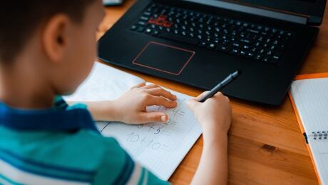 Distance learning online education. A schoolboy boy studies at home and does school homework. A home distance learning.; Shutterstock ID 1680603754 Shutterstock - Huge file