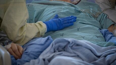 A nurse tends to a patient suspected of having COVID-19 in the intensive care unit at North York General Hospital in Toronto in May. NYGH