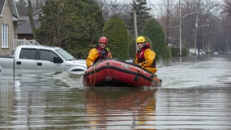 Firefighters make their way through a flooded street on Friday, May 3, 2019 in Ste-Marthe-sur-la-Lac, Quebec. A federal review says the government had trouble spending half of the $184 million earmarked to prevent flood damage in Canadian communities. Flood Prevention 20200130