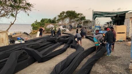 Workers prepare sea booms in an effort to contain the spill. Mauritius oil spill