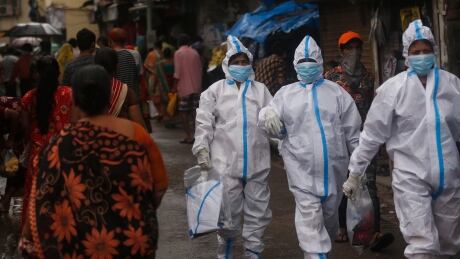 Health workers return after screening people for COVID-19 symptoms in Dharavi, one of Asia's biggest slums, in Mumbai, India, Tuesday, Aug. 11, 2020. India has the third-highest coronavirus caseload in the world after the United States and Brazil. Virus Outbreak India