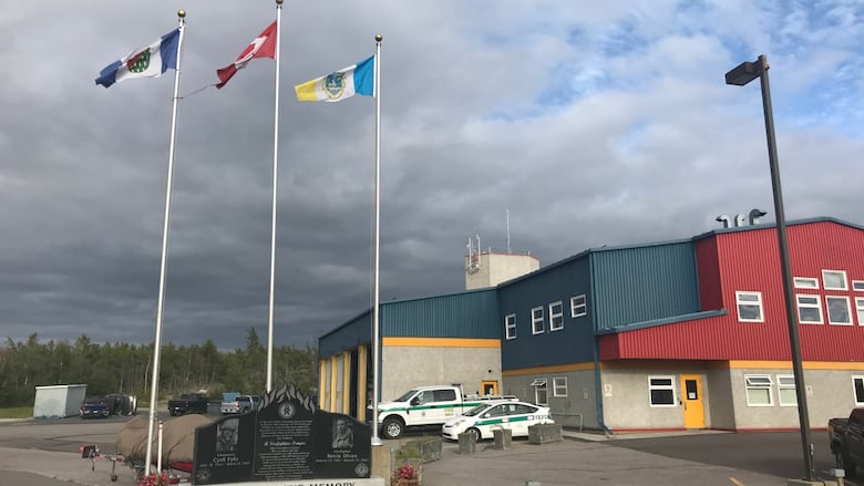 A red and blue building with flags beside it.