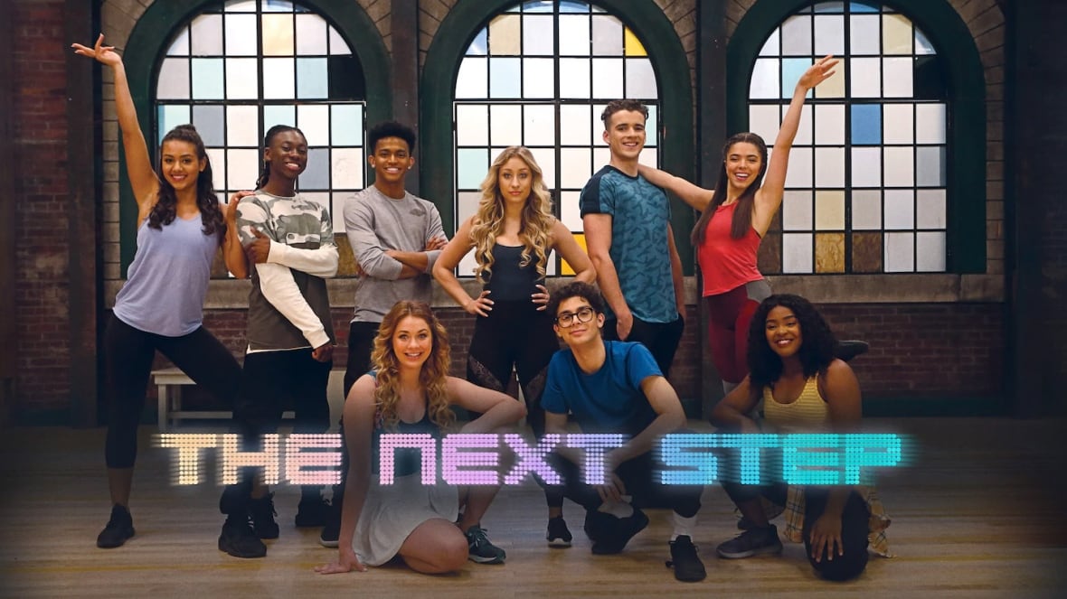 nine young people stand in a group in various dance poses. the words "The Next Step" run across the bottom of the image