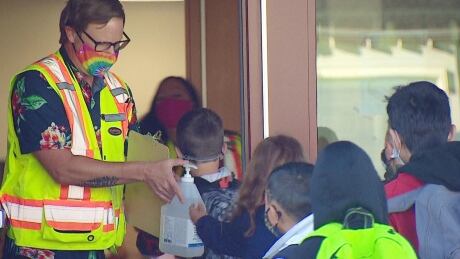 Students line up to have their hands sanitized at Eric Harvie School in northwest Calgary on the first day back to school on Tuesday. back to school Calgary