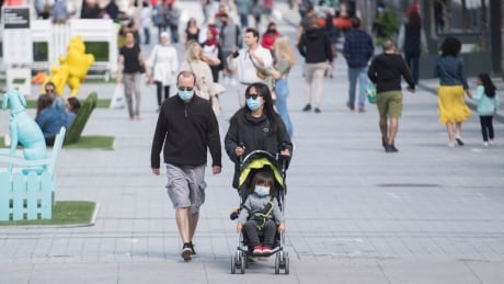 People wear face masks as they walk along a street in Montreal, Saturday, Sept. 5, 2020, as the COVID-19 pandemic continues in Canada and around the world. COVID Que 20200905