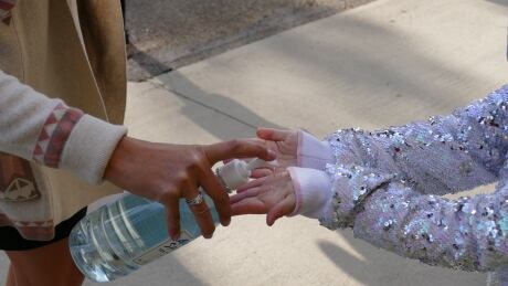 A student sanitizes their hands before entering school. 127480