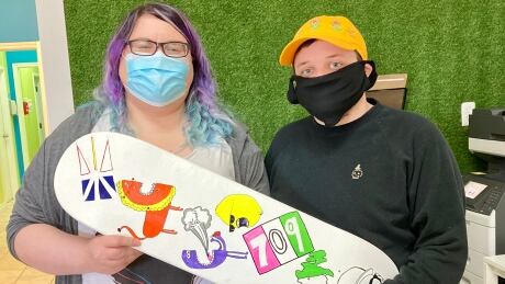 Nikki Baldwin, left, with one of the custom-designed skateboard decks created by young people through NL Boards. NL Boards