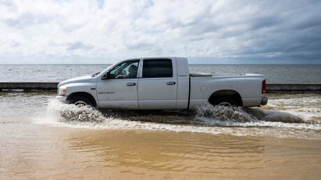 A truck plows through seawater as Beach Boulevard floods in Waveland, Miss., Monday, Sept. 14, 2020. Winds from Hurricane Sally mixed with the high tide pushed waters across the seawall that separates the low lying roadway that borders much of the Mississippi Gulf Coast. Tropical Weather Mississippi