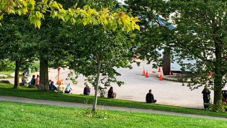 A number of people waited along the curb at the Oakridge Arena to get tested for COVID-19. There were 355 people swabbed at the west-end assessment centre on Monday. people waiting for a COVID-19 test