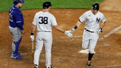 New York Yankees infielder DJ LeMahieu, right, is congratulated by teammate Erik Kratz after hitting a home run during the team's 20-6 win over the Toronto Blue Jays on Tuesday. Blue Jays Yankees Baseball