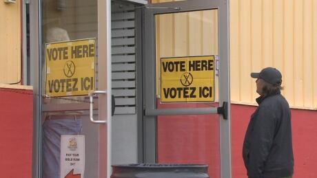 Voters line up at a polling station in Fredericton during New Brunswick's 2020 provincial election. It's unclear when over the next few months a municipal election delayed by the pandemic will take place. Election polling station 2020 provincial election