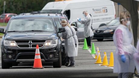 Hundreds of cars lined up in front of tents at the Jean-Belliveau arena in Longueuil on Thursday as people waited to get tested at the drive-through clinic. drive-through